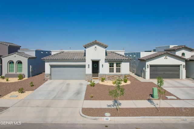 951 Airship Pl, El Paso, TX 79928 - mediterranean / spanish-style house featuring driveway, an attached garage, a tiled roof, and stucco siding