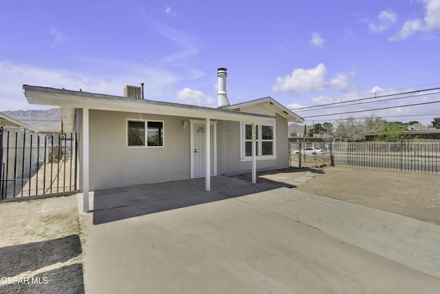view of front of house featuring stucco siding, fence, and a patio area