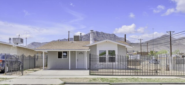 ranch-style home with stucco siding, a chimney, fence, and a mountain view