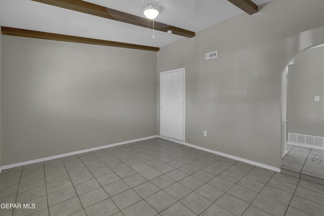 empty room featuring arched walkways, beam ceiling, and visible vents