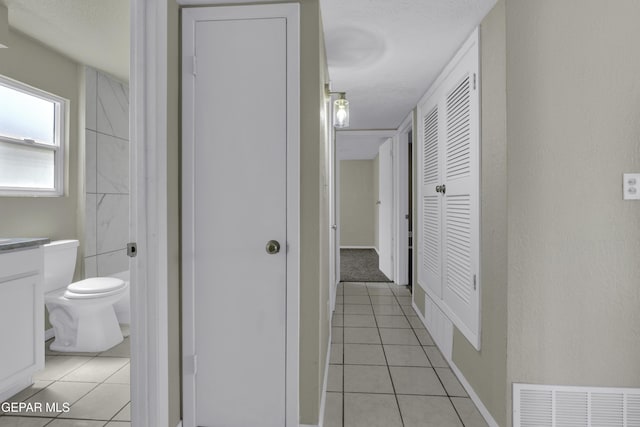 corridor with visible vents and light tile patterned floors
