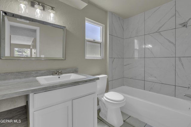 bathroom featuring toilet, vanity, tile patterned floors, and shower / bathing tub combination