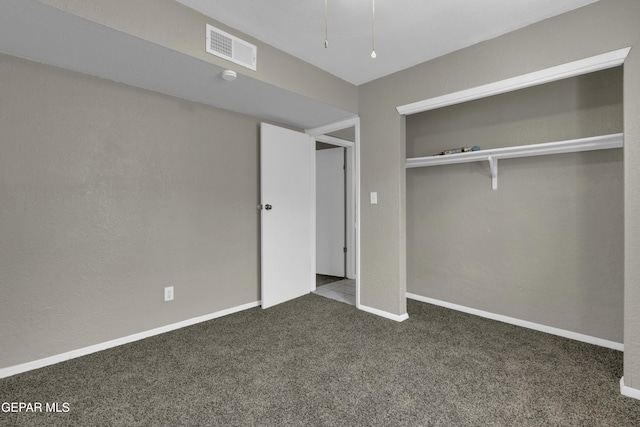 unfurnished bedroom with a closet, carpet, visible vents, and baseboards