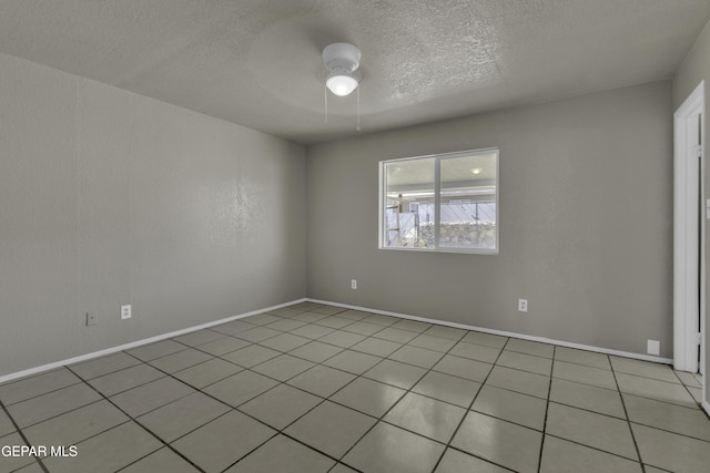 unfurnished room with a textured ceiling, baseboards, ceiling fan, and light tile patterned floors