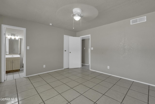 unfurnished room featuring baseboards, a ceiling fan, visible vents, and light tile patterned floors