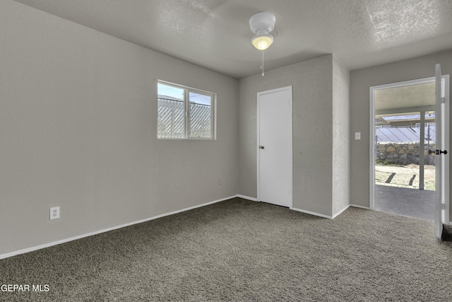 unfurnished room featuring ceiling fan, baseboards, a textured ceiling, and carpet