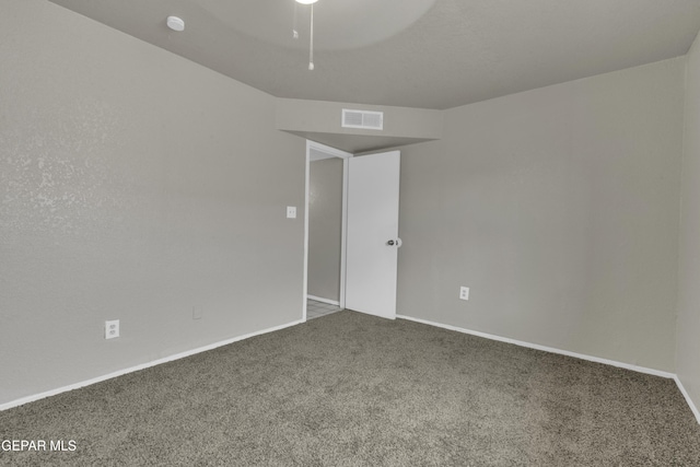 carpeted spare room with baseboards, visible vents, and ceiling fan