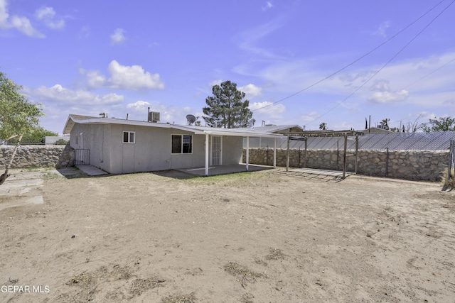 rear view of house with a patio area, a fenced backyard, and stucco siding