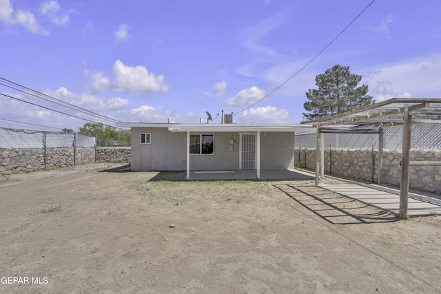 back of house with fence, a patio, and stucco siding