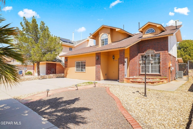 view of front of home featuring a gate, brick siding, and fence