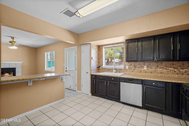 kitchen with decorative backsplash, stainless steel dishwasher, a sink, and a ceiling fan