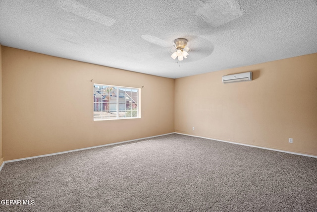 carpeted spare room with baseboards, a textured ceiling, a wall unit AC, and ceiling fan