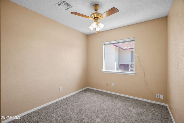 carpeted empty room with a textured ceiling, visible vents, baseboards, and ceiling fan