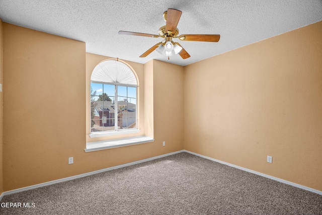 carpeted spare room with ceiling fan, baseboards, and a textured ceiling