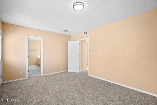 unfurnished bedroom featuring baseboards, visible vents, carpet, and connected bathroom