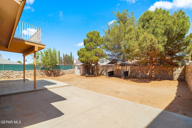 view of patio / terrace featuring an outbuilding, a fenced backyard, and a balcony