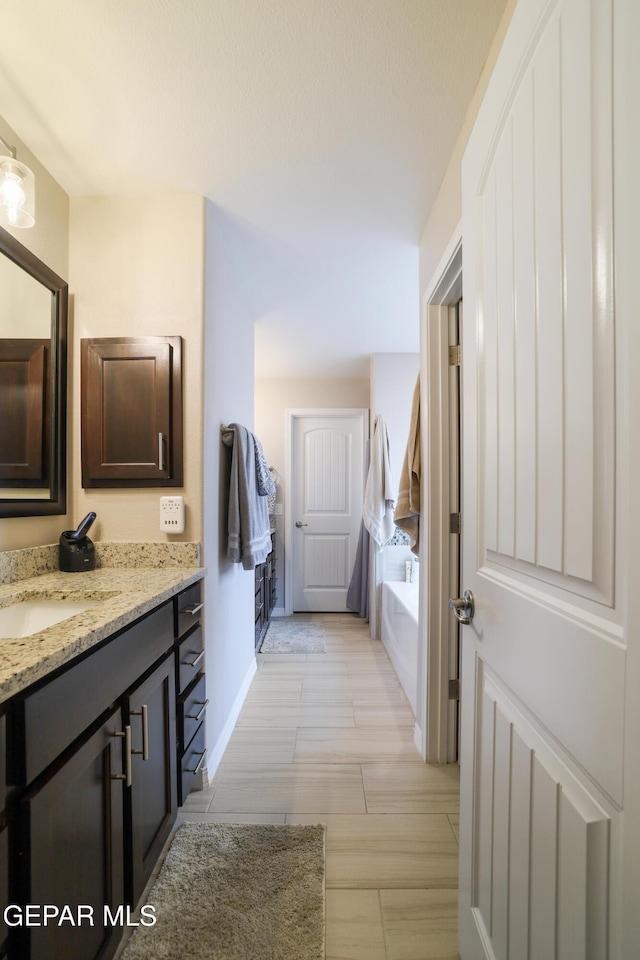 7825 Enchanted Ridge Dr, El Paso, TX 79911 - bathroom with a bath, baseboards, and vanity