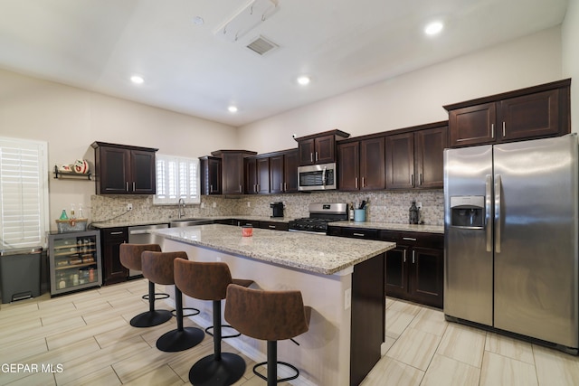 7825 Enchanted Ridge Dr, El Paso, TX 79911 - kitchen featuring stainless steel appliances, wine cooler, a sink, visible vents, and a kitchen island