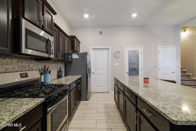 7825 Enchanted Ridge Dr, El Paso, TX 79911 - kitchen with stainless steel appliances, a center island, visible vents, backsplash, and light stone counters