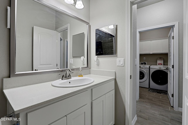 13877 Paseo Perlas Dr, El Paso, TX 79928 - bathroom with wood finished floors, washer and clothes dryer, and vanity