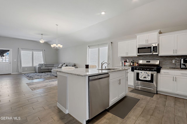 13877 Paseo Perlas Dr, El Paso, TX 79928 - kitchen featuring a sink, a chandelier, light wood-style flooring, appliances with stainless steel finishes, and open floor plan