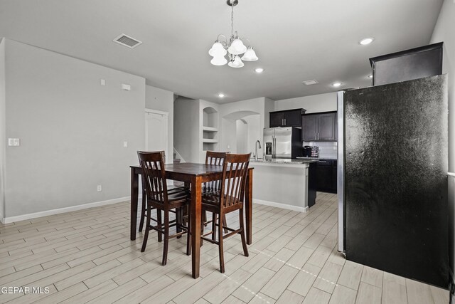 dining room featuring recessed lighting, a notable chandelier, visible vents, baseboards, and arched walkways