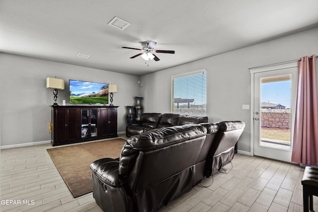 living area with a ceiling fan, visible vents, baseboards, and light wood-style floors