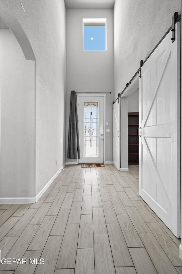foyer entrance featuring arched walkways, a wealth of natural light, and a barn door