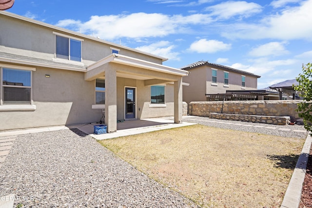 back of property featuring a patio, stucco siding, and a fenced backyard