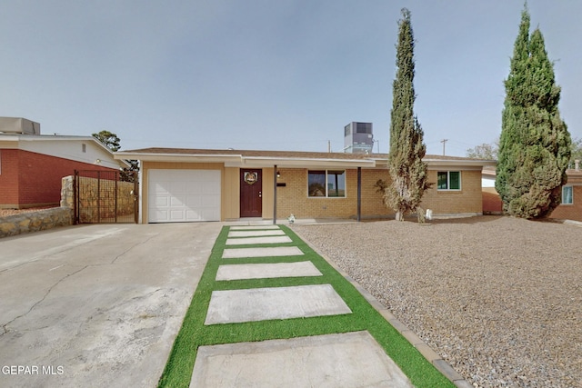 single story home featuring central AC unit, concrete driveway, a chimney, a garage, and brick siding