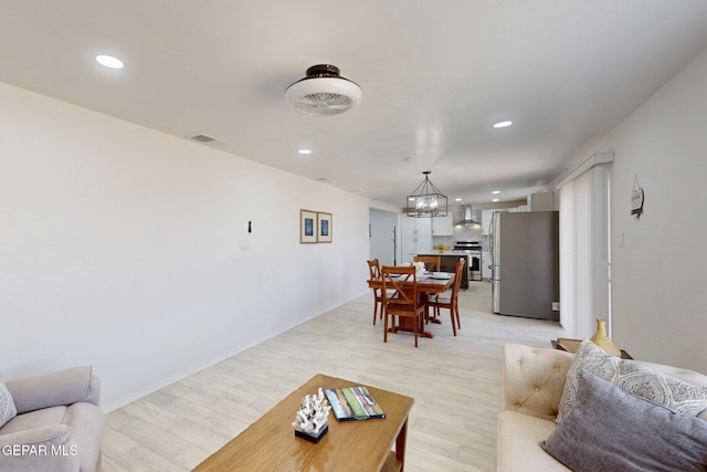 living room with recessed lighting, light wood-type flooring, visible vents, and a notable chandelier