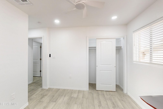 unfurnished bedroom with baseboards, wood finished floors, visible vents, and a closet
