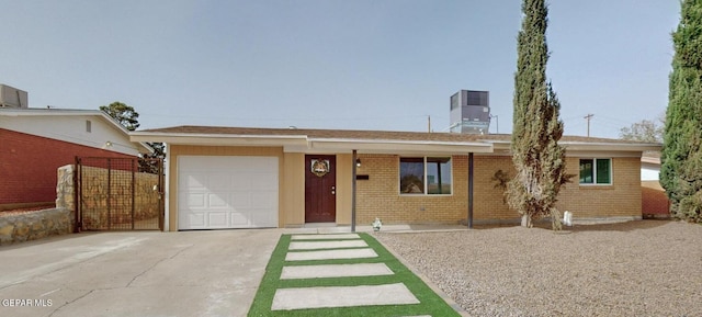 ranch-style home with central AC unit, driveway, a chimney, brick siding, and a garage