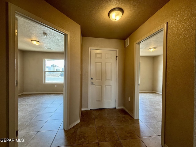 312 Via Cumbre Linda Cir, El Paso, TX 79928 - hall featuring baseboards, tile patterned floors, a textured ceiling, and visible vents
