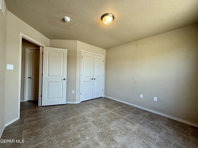 312 Via Cumbre Linda Cir, El Paso, TX 79928 - unfurnished bedroom featuring a closet, a textured ceiling, and baseboards