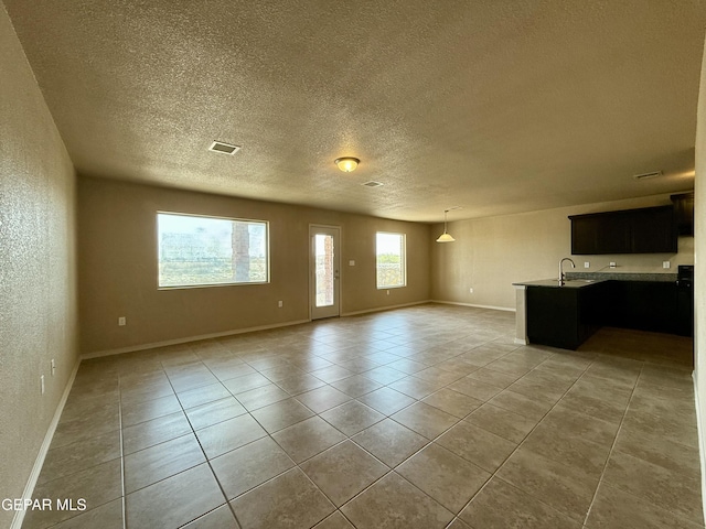 312 Via Cumbre Linda Cir, El Paso, TX 79928 - unfurnished living room featuring light tile patterned flooring, plenty of natural light, and a textured ceiling
