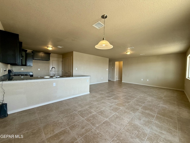 312 Via Cumbre Linda Cir, El Paso, TX 79928 - kitchen featuring dark countertops, a sink, visible vents, and a textured ceiling