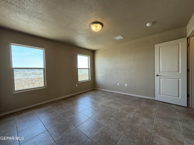 312 Via Cumbre Linda Cir, El Paso, TX 79928 - spare room featuring baseboards, tile patterned flooring, and a textured ceiling