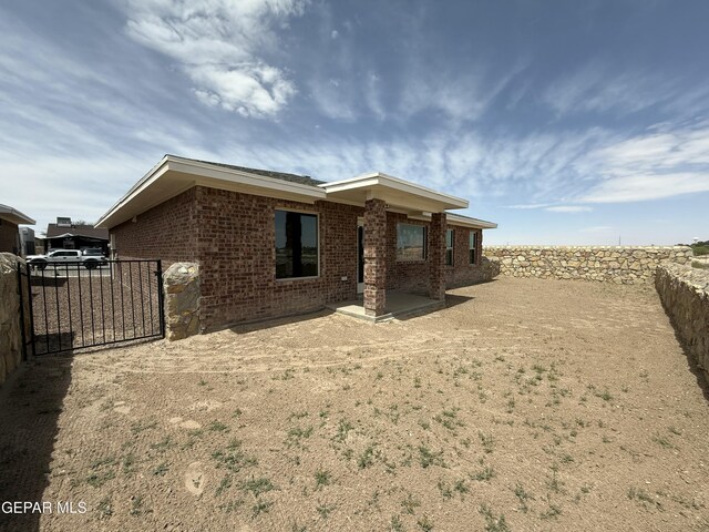312 Via Cumbre Linda Cir, El Paso, TX 79928 - back of house featuring brick siding, a patio, fence, and a gate