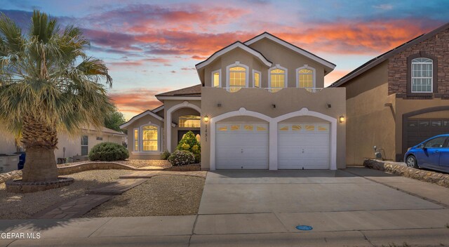 mediterranean / spanish-style house with stucco siding, driveway, and an attached garage