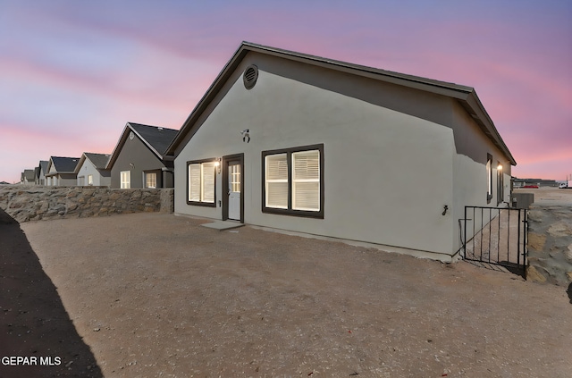 1205 Night Sky St, Horizon City, TX 79928 - back of property at dusk featuring fence, a patio, and stucco siding