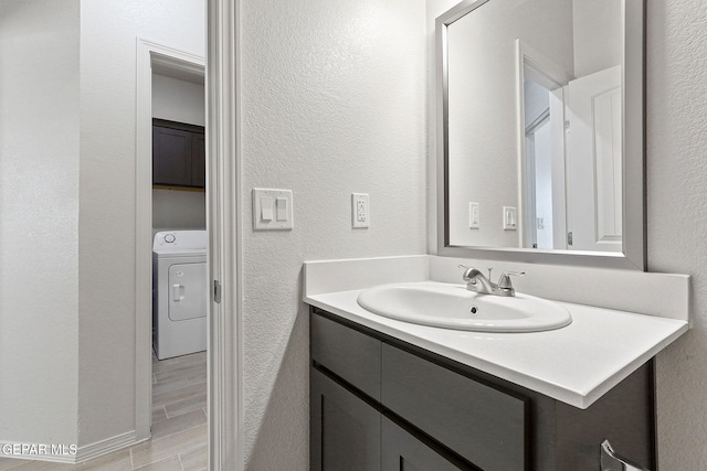 1205 Night Sky St, Horizon City, TX 79928 - bathroom with wood finished floors, washer / clothes dryer, vanity, and a textured wall