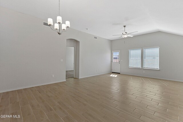 1205 Night Sky St, Horizon City, TX 79928 - unfurnished living room with vaulted ceiling, visible vents, arched walkways, light wood-type flooring, and ceiling fan with notable chandelier