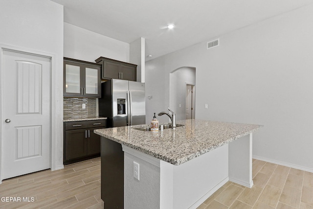 1205 Night Sky St, Horizon City, TX 79928 - kitchen featuring arched walkways, wood finish floors, a sink, and stainless steel fridge with ice dispenser