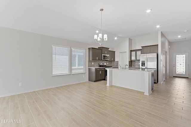1205 Night Sky St, Horizon City, TX 79928 - kitchen featuring open floor plan, an inviting chandelier, backsplash, lofted ceiling, and appliances with stainless steel finishes