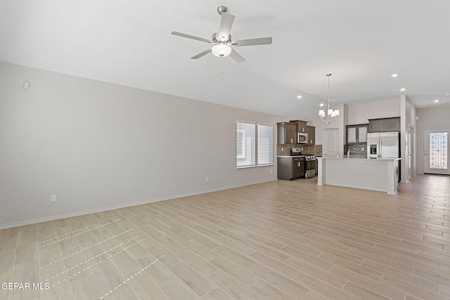 1205 Night Sky St, Horizon City, TX 79928 - unfurnished living room with recessed lighting, baseboards, lofted ceiling, and ceiling fan with notable chandelier