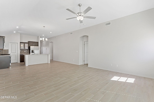 1205 Night Sky St, Horizon City, TX 79928 - unfurnished living room with arched walkways, baseboards, visible vents, ceiling fan with notable chandelier, and lofted ceiling