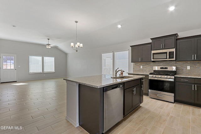 1205 Night Sky St, Horizon City, TX 79928 - kitchen with stainless steel appliances, a sink, open floor plan, lofted ceiling, and decorative backsplash