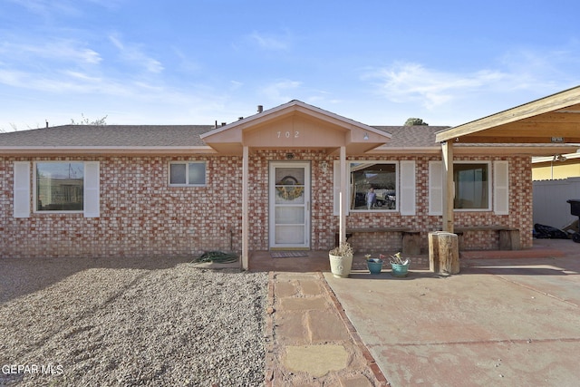 ranch-style home with brick siding and a shingled roof
