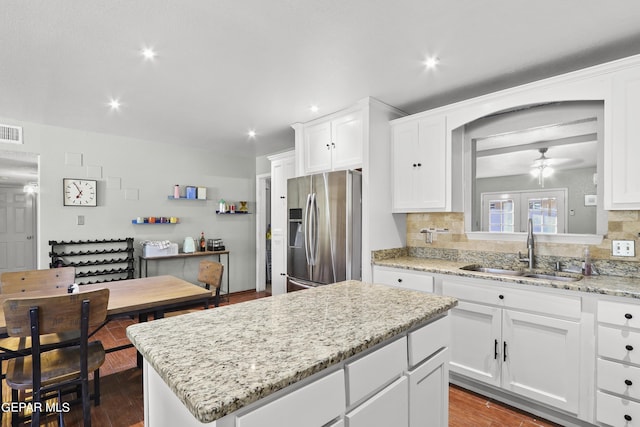 kitchen featuring recessed lighting, a center island, a sink, and stainless steel fridge with ice dispenser